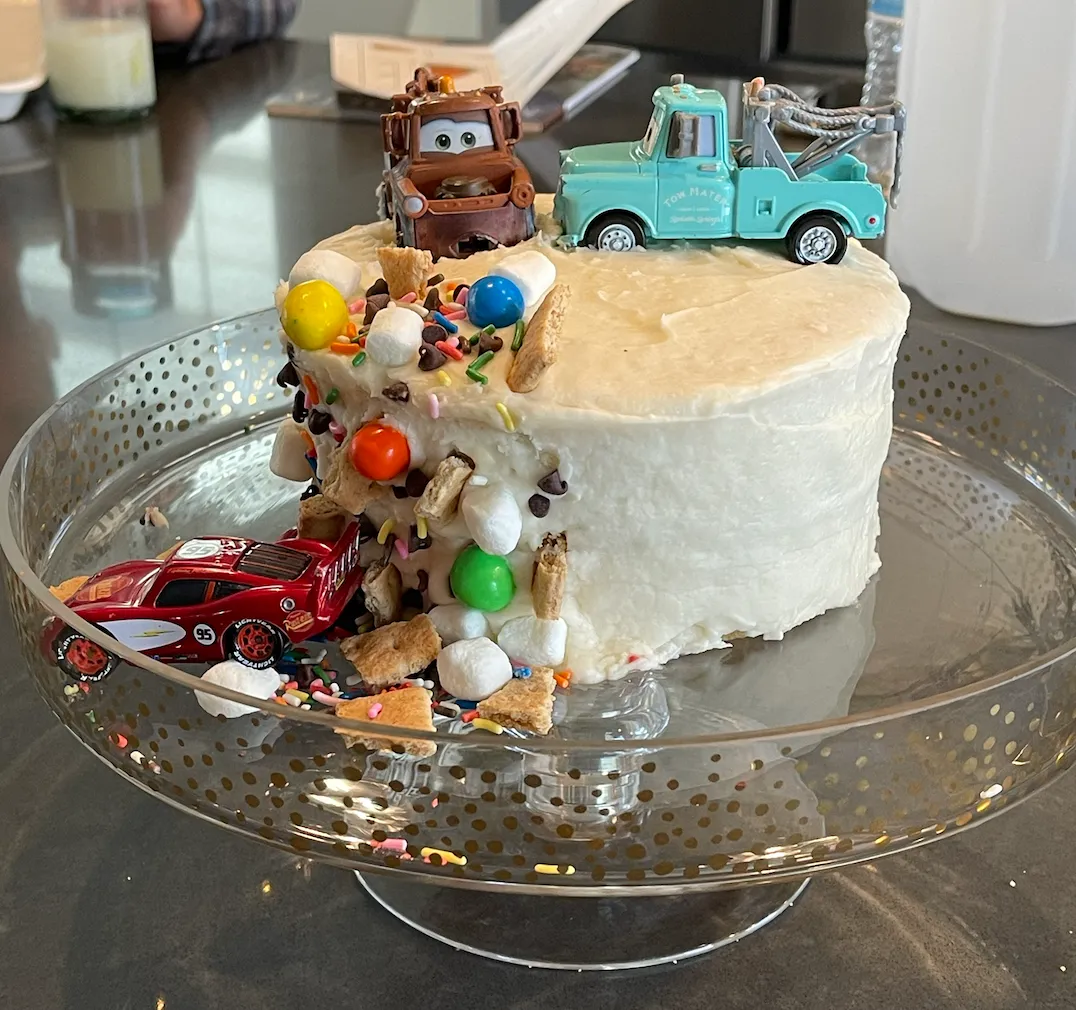A whimsical dump truck birthday cake carrying a mound of cookie crumbs, styled as a loving first-cake memory.